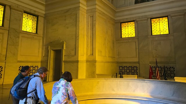 A Park Volunteer talks with visitors inside the Mausoleum
