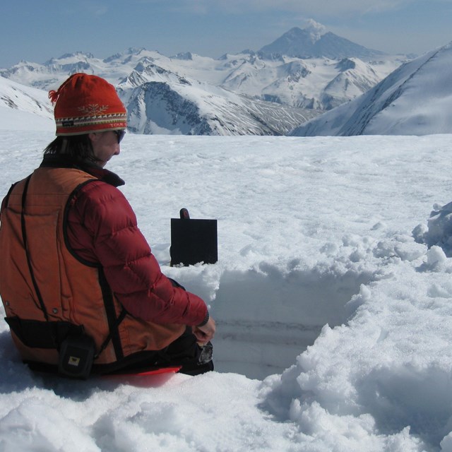 person in snow survey pit