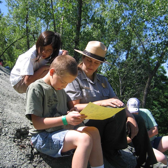 ranger with children at a fossil site
