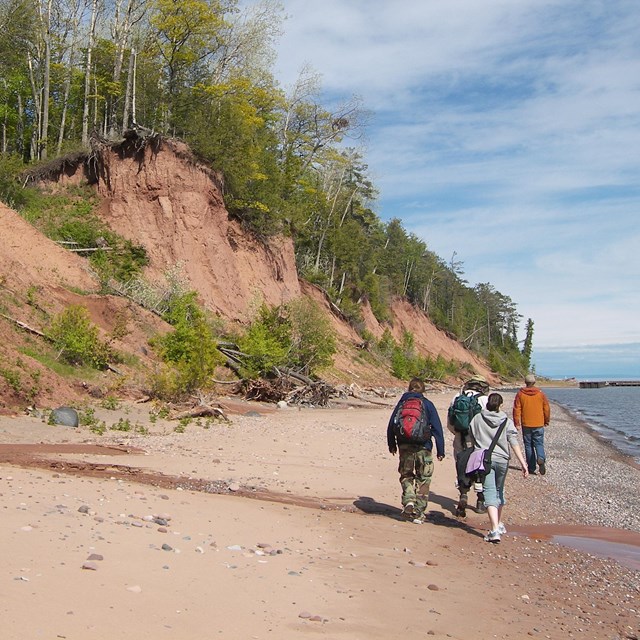 red-hued shoreline bluffs and sand beach