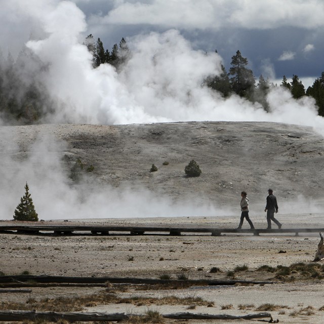 two people walking in area with steam rising from the ground