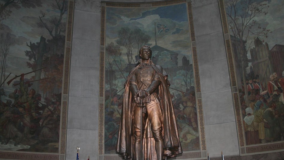 Clark statue and 3 murals behind him