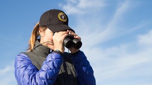 Volunteer looking through binoculars