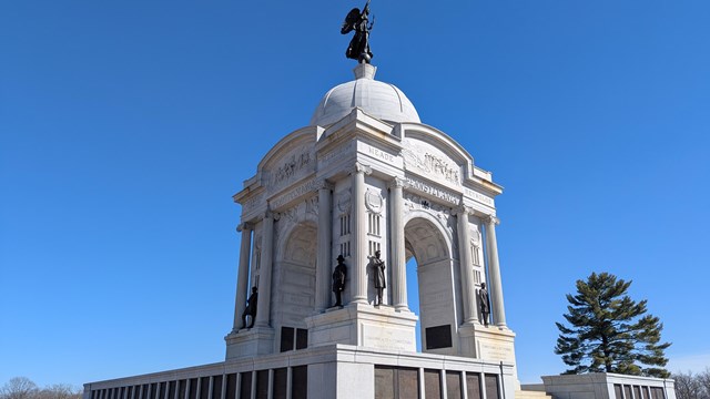 Large stone monument with bronze figures and bronze plaques