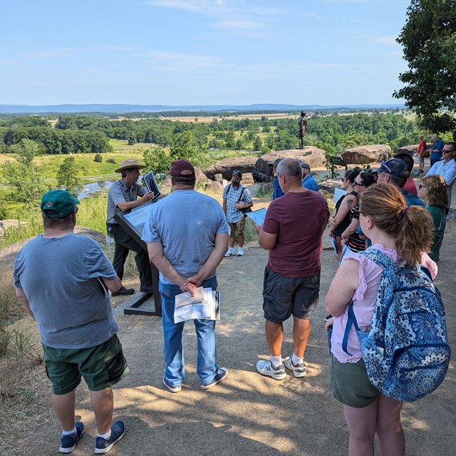 Educators listen to a park ranger talk on Little Round Top