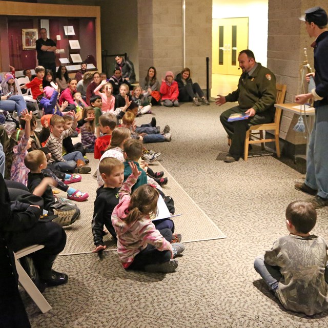 A Park Ranger Reads a Book to a Group of Young Children