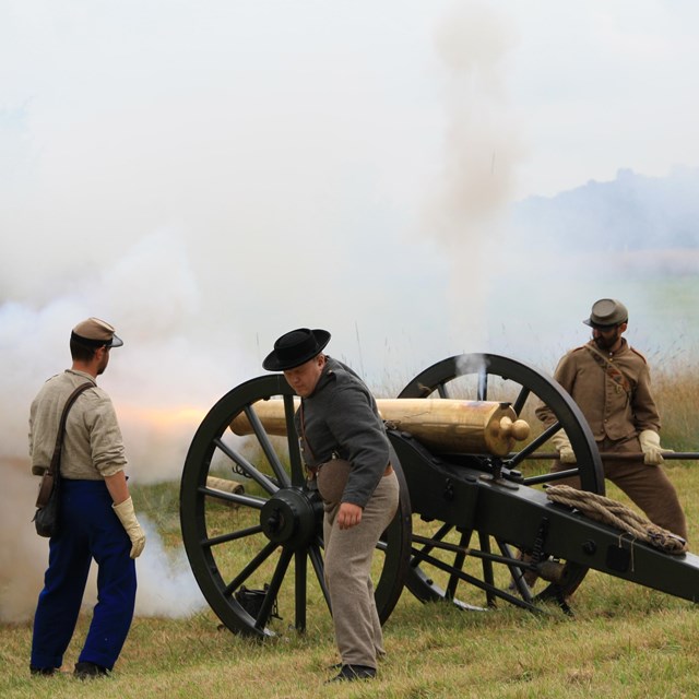 A group of Confederate artillery living historians fire a cannon during a demonstration.