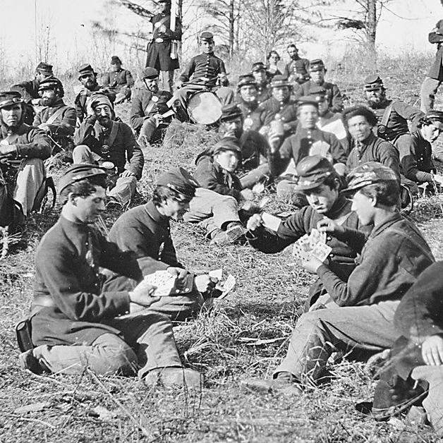 Soldiers play cards in camp