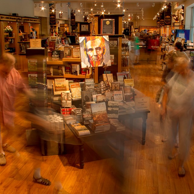 A view of the bookstore with visitors shopping and walking around. 