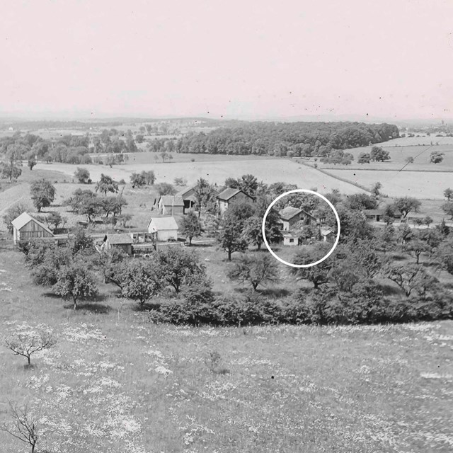 A black and white photo shows the Warfield house property in the early 1900s.