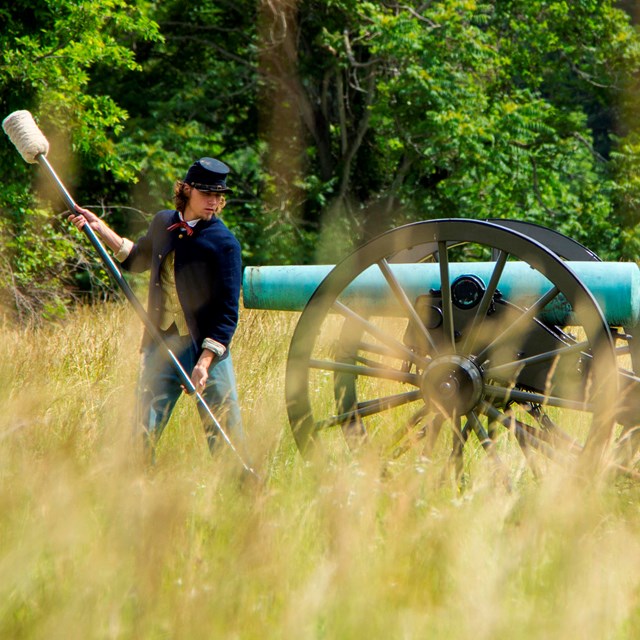 A park employee demonstrates how to load a civil war cannon during a living history program.