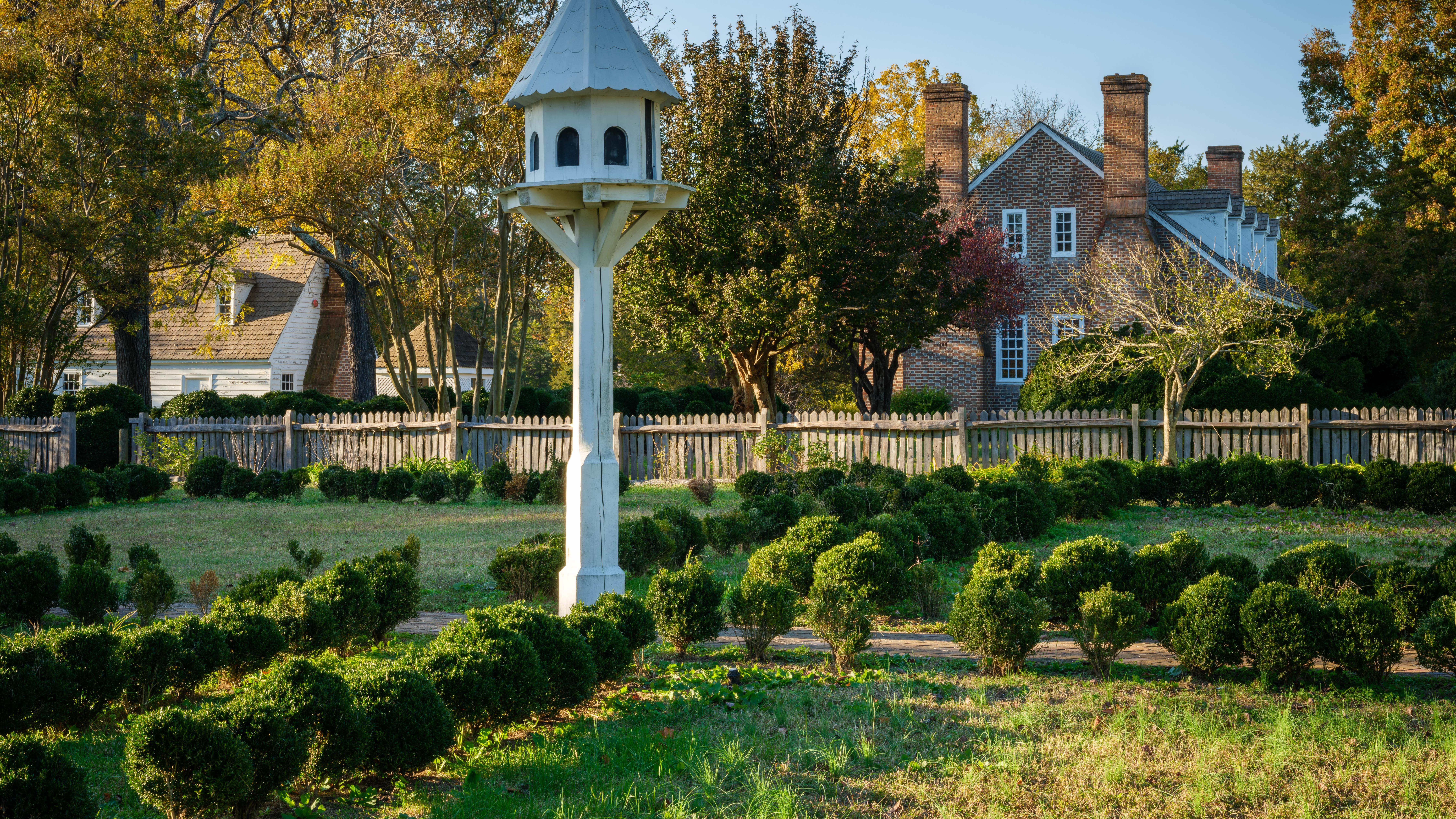 Birdhouse in center of the colonial garden. Text reads, "Colonial Revival Garden"
