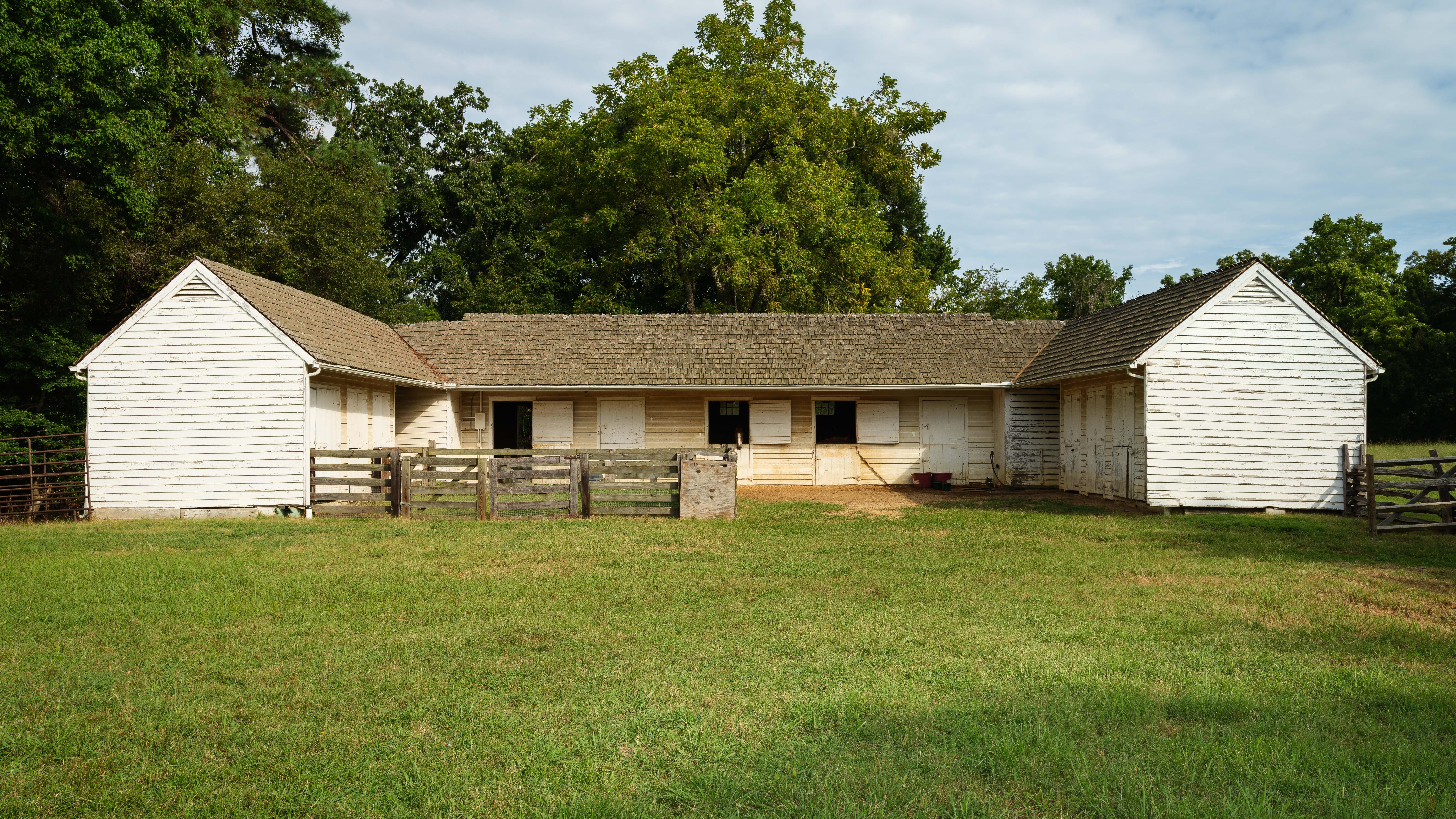 A white barn in the shape of a U.