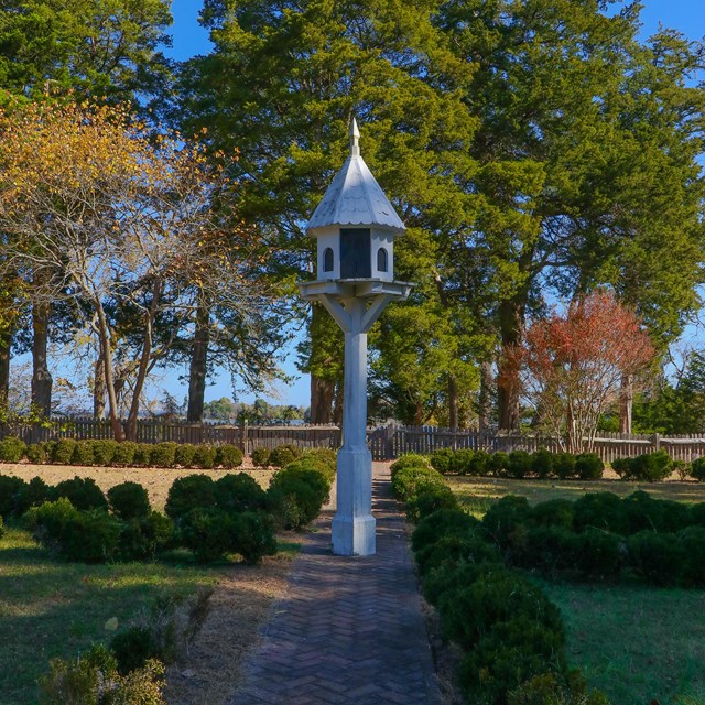A dove cote sits in the middle of a large garden.