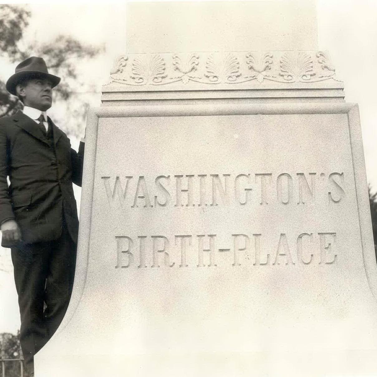 sepia photo of man standing next to the birthplace monument