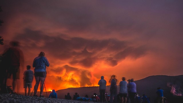People watch a wildfire.