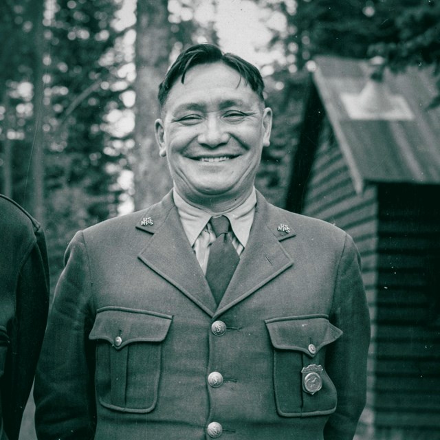 A park ranger in uniform smiles at the camera.