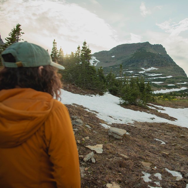 The sun flares on a hiker in the mountains