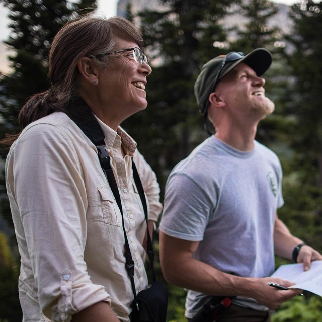 Two scientists stand smiling outside