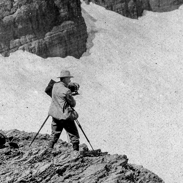 Historic image of a person photographing a glacier