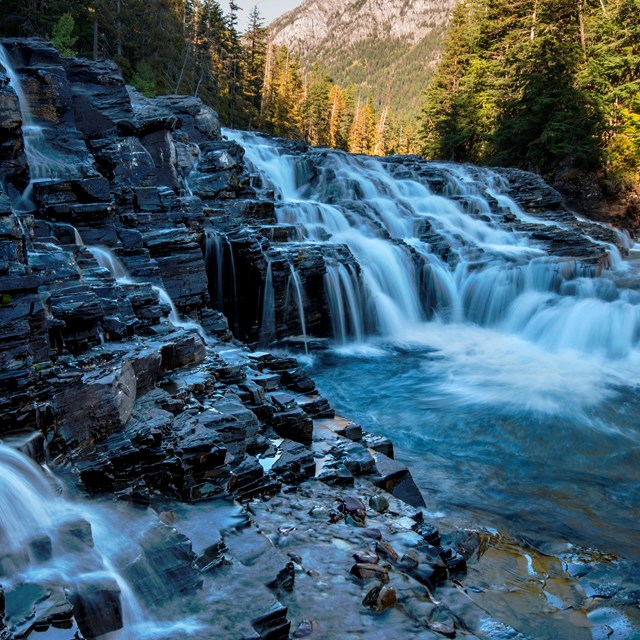 Water rushes down the site of a rocky cliff