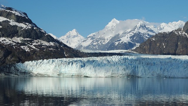a tidewater glacier with mountains surrounding