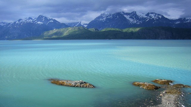 turquoise waters near a sandy beach and mountains