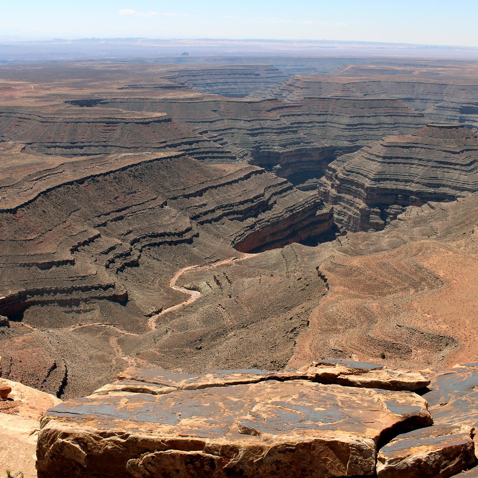 View from high rocky point overlooking twisting canyon carved in rock layers