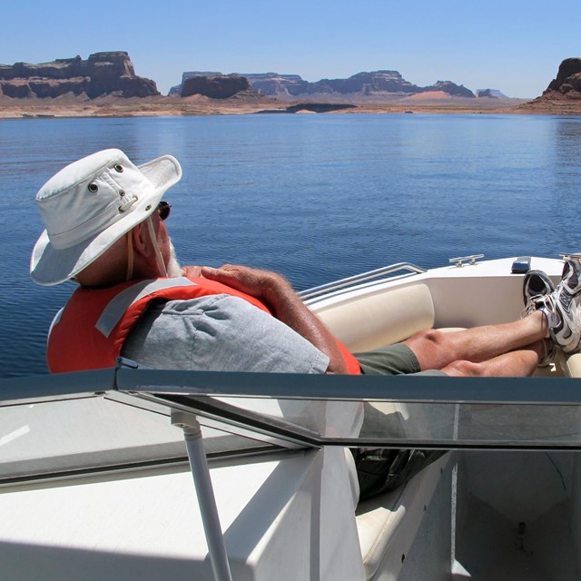 Man relaxes at front of motorboat on Lake Powell