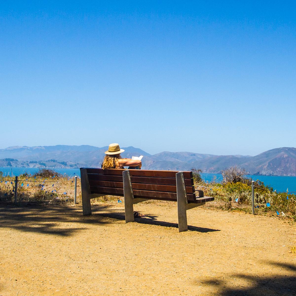 Visitor enjoying view from park bench on the Land's End trail