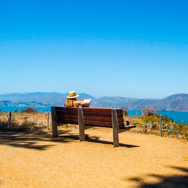 Visitor enjoying view from park bench on the Land's End trail
