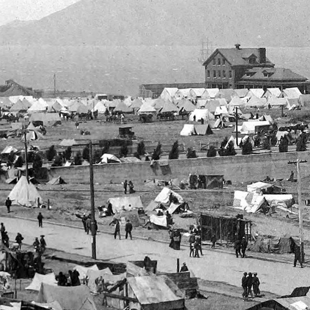 army tents and buildings along waterfront of old fort mason