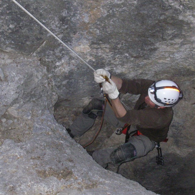 Person using single rope technique to exit a wild cave