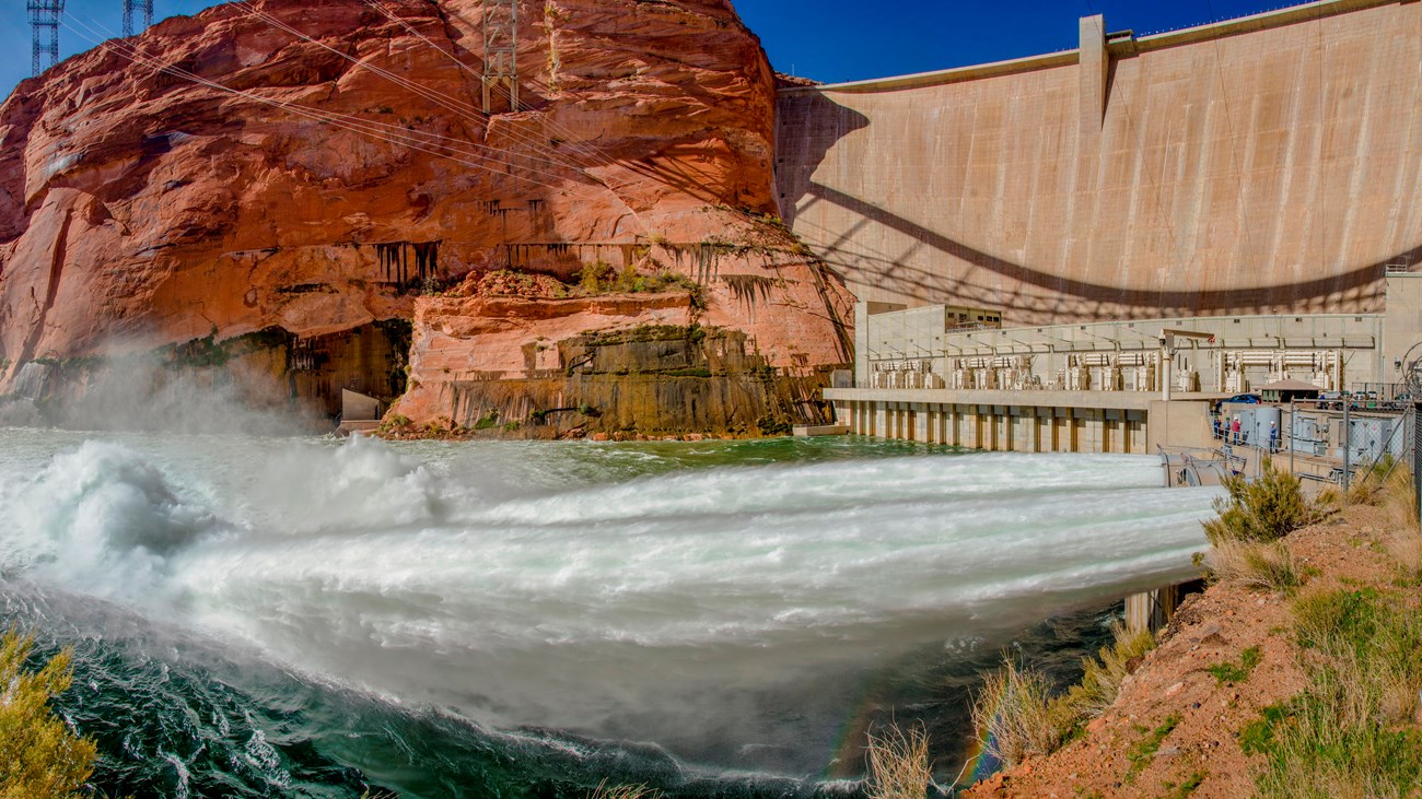In the foreground, jets of water being released from the base of Glen Canyon Dam. 