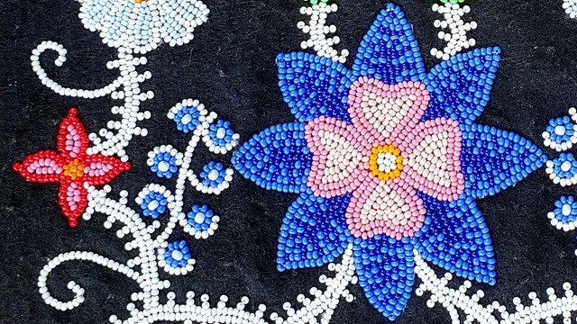 Traditional Ojibwe floral pattern beadwork on a black backeground.