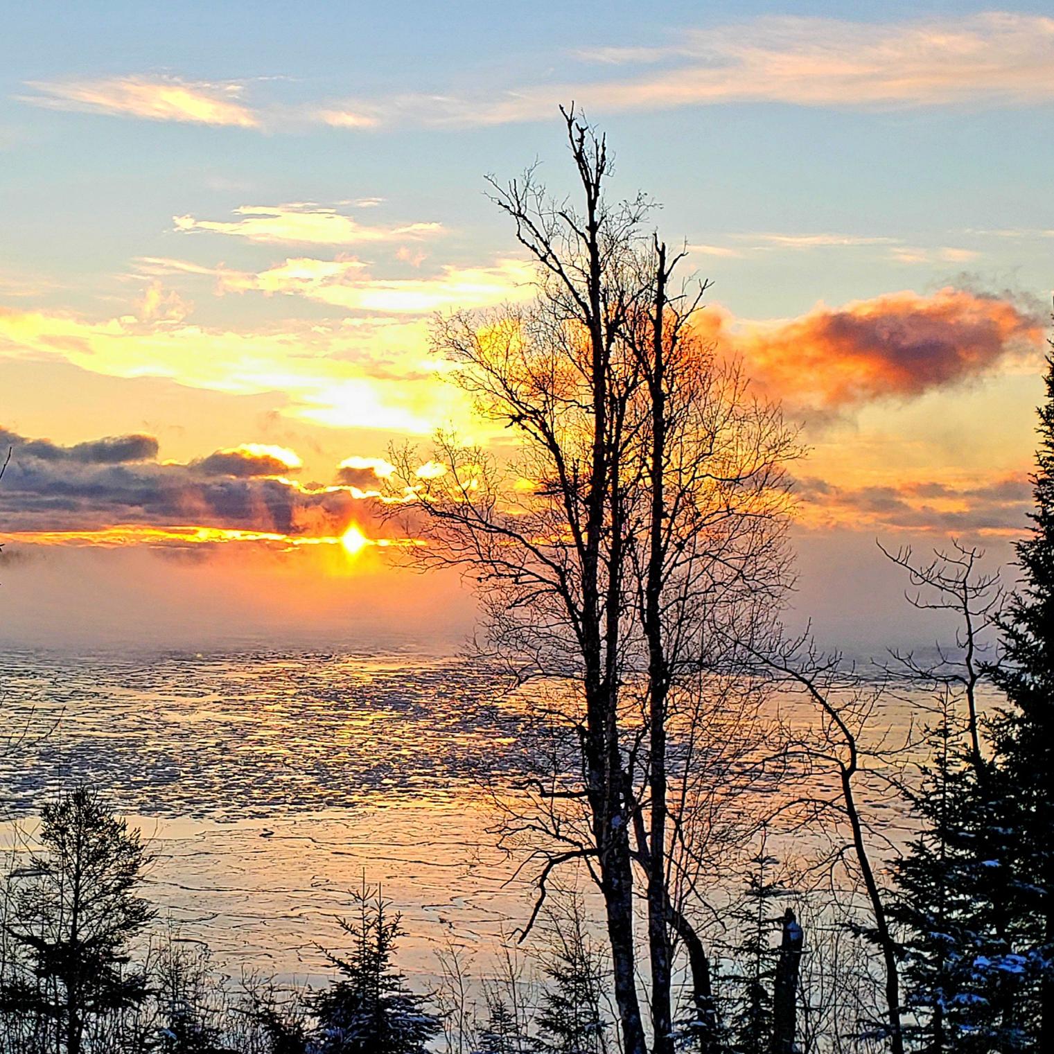 Sunrise over a foggy bay.