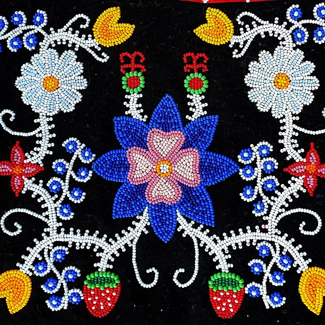 Traditional Ojibwe beaded flowers on a black background.