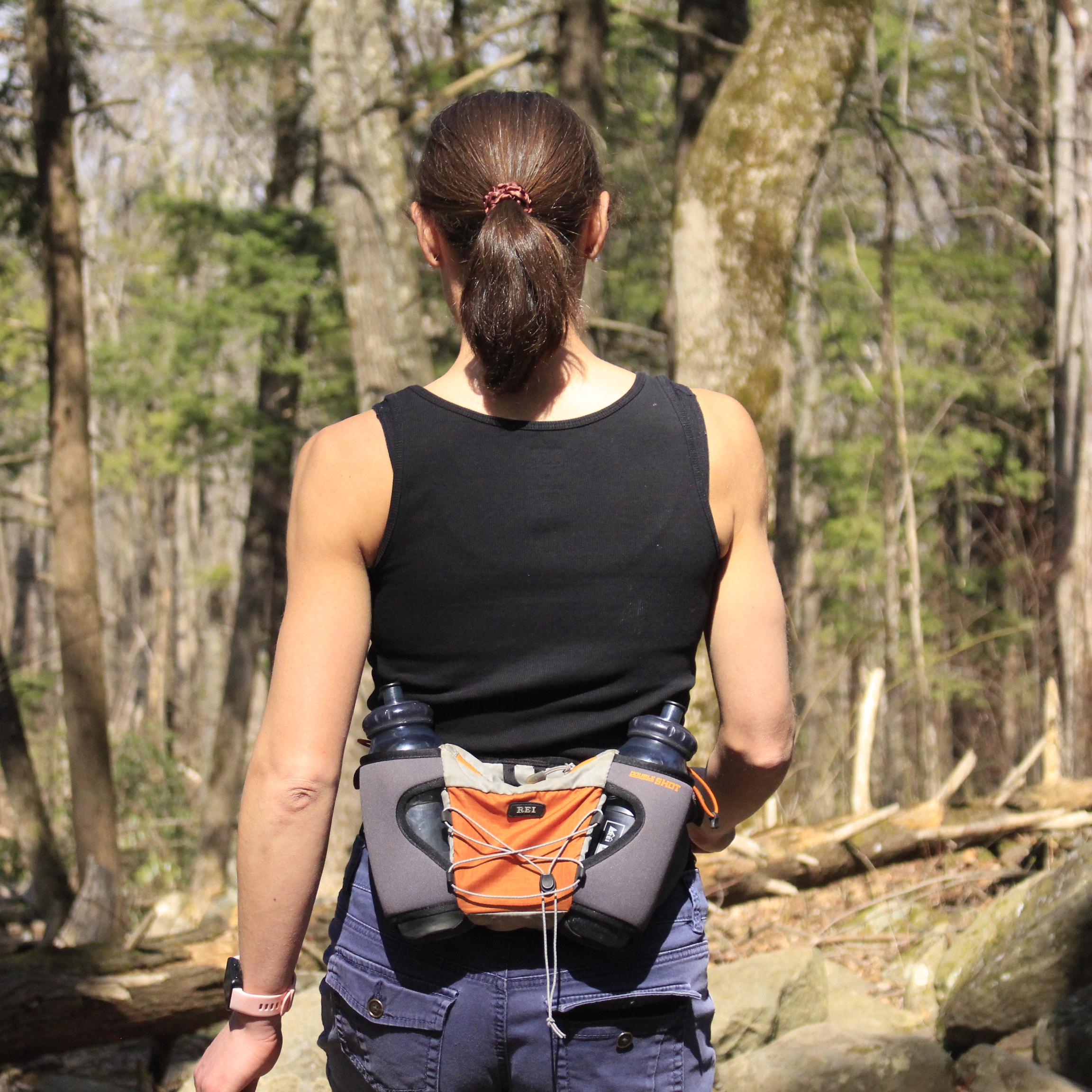 The back of a person walking on a trail.