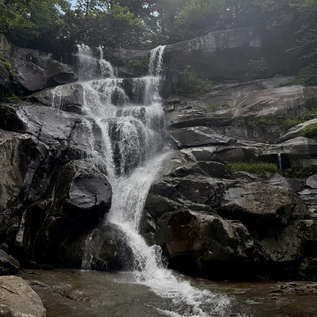 A large waterfall cascading down jagged rocks.