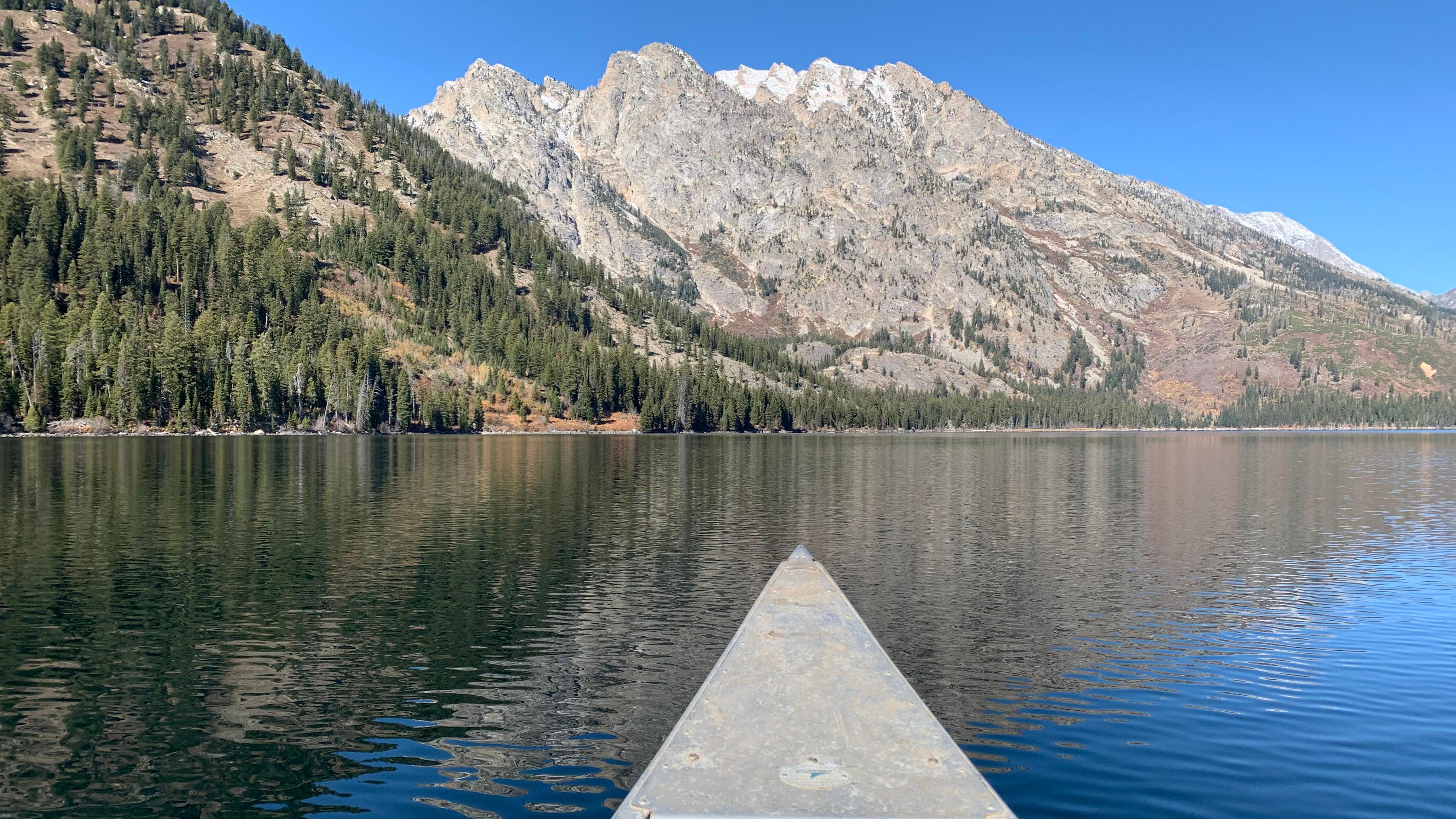 The front of a canoe on a lake.