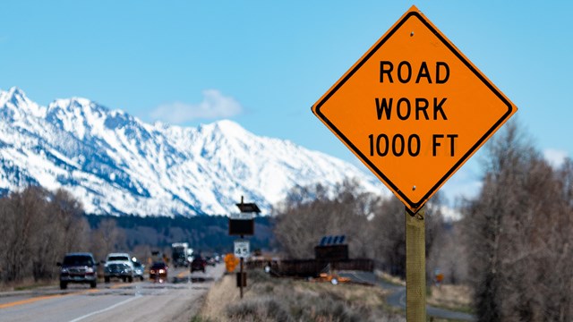Road Work 1000ft orange sign with mountains in the background