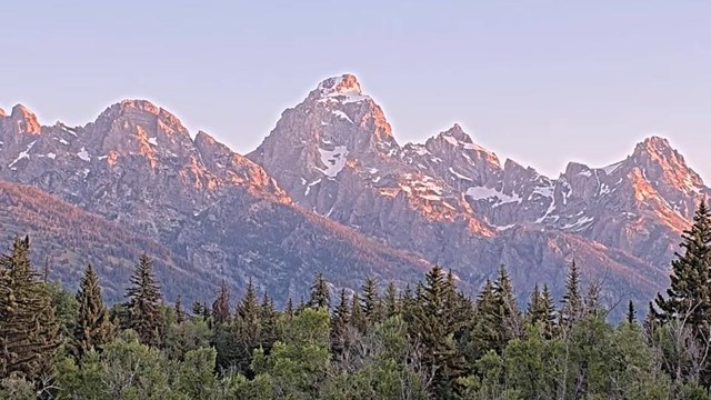 This webcam captures a classic panoramic view of the Teton Range, seen from a distance that allows f