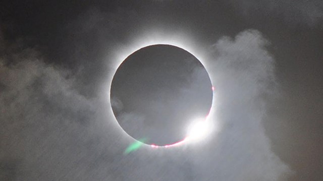 Visitors looking at the sun with eclipse glasses.