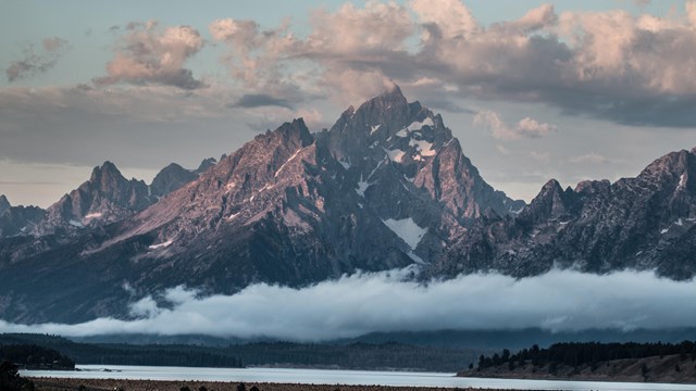 Clouds surround the Teton Range and fog covers the valley