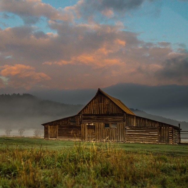 A barn surrounded by mist.