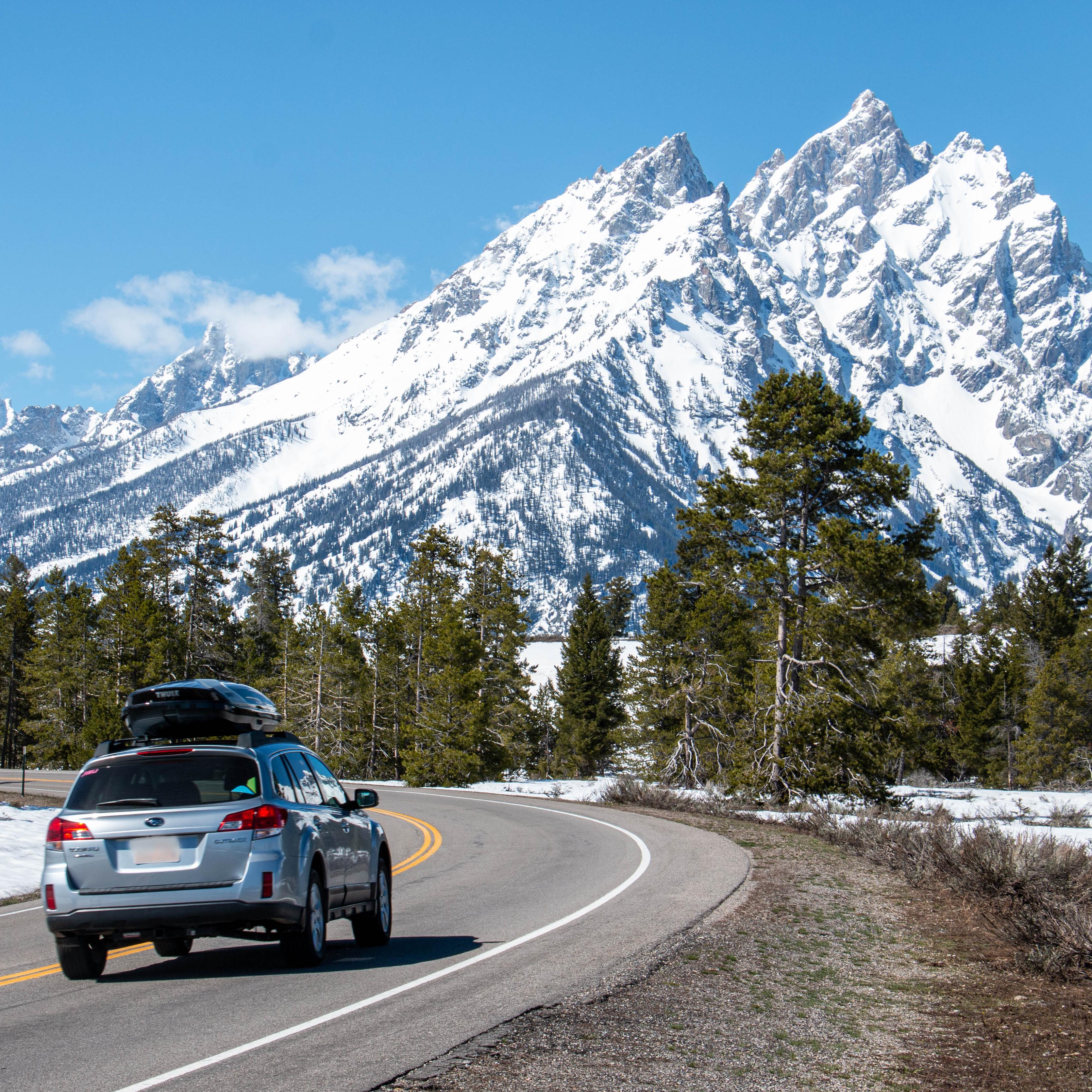 A car drives on a road towards mountains.