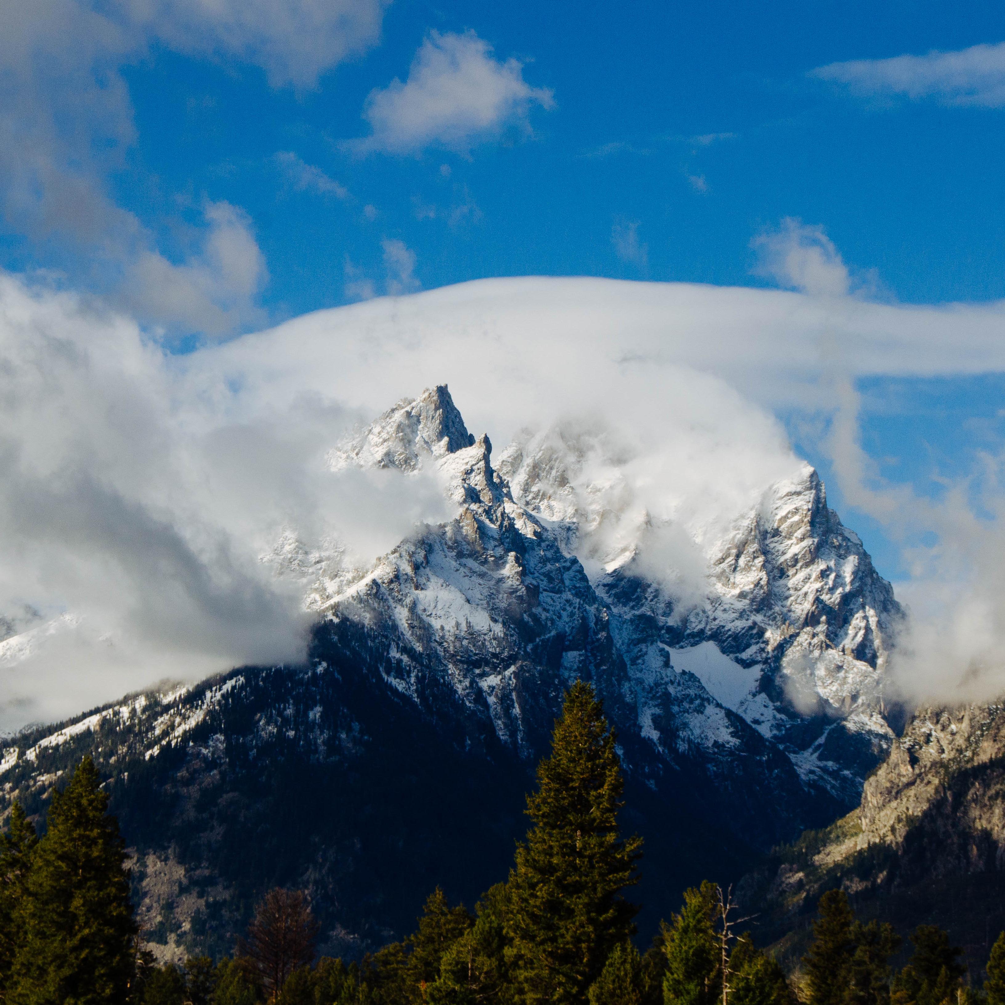 Clouds rise off of mountains.