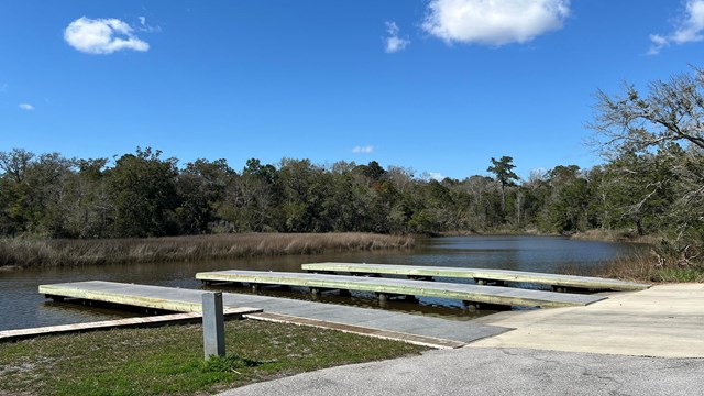 A National Park Service boat rests on top of blue green water.
