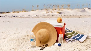 A pile of gear sites on a sandy beach.