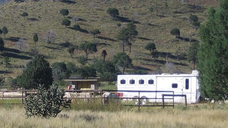 A metal fenced horse corral with a trailer